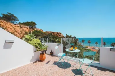 a balcony with a table and chairs and the ocean at Casa do Cacto in Olhos de Água