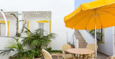 a patio with a table and an umbrella at Residencial Miramar in Quarteira