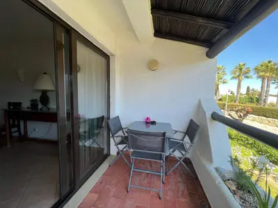 a balcony with a table and chairs and a desk at Apartamento Perfect Holidays in Albufeira