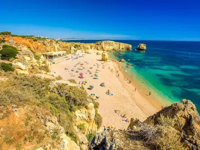 a group of people on a beach near the ocean at Luxury Apart wStunning Sea Views, walk Galé Beach Albufeira in Albufeira