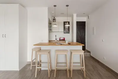 a kitchen with a island with bar stools at Estúdio 21 em Santa Bárbara de Nexe - Faro in Santa Bárbara de Nexe