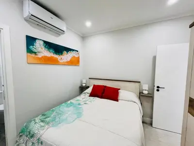 a bedroom with a bed with a red pillow at Brisamar Villas OCEANS in Albufeira