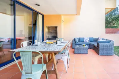 a patio with a table and chairs and a couch at 2 bedroom Vila Sol Golf Resort in Quarteira