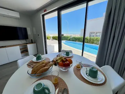 a table with food on it with a view of a pool at Albufeira Stylish 2 With Pool by Homing in Albufeira