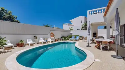 a swimming pool in a patio with chairs and a table at Villa Frederique by Gabi Miguel in Albufeira
