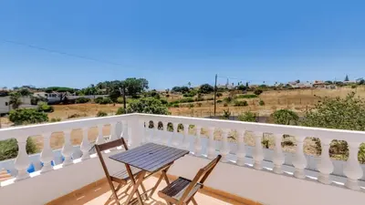 a table and chairs on a balcony with a view at Villa Frederique by Gabi Miguel in Albufeira