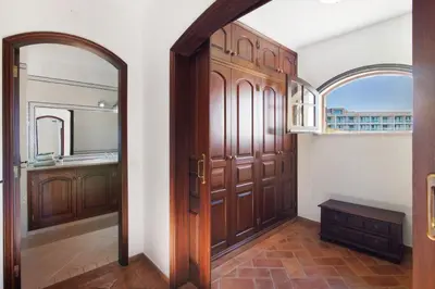 a hallway with a wooden door and a mirror at Villa Rústica in Albufeira