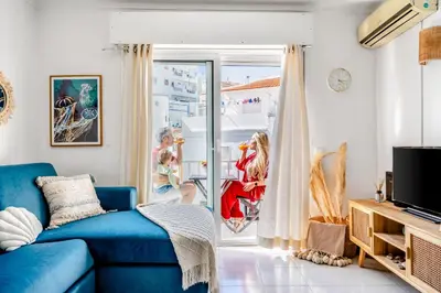 a living room with a blue couch and a sliding glass door at Stay in Old Town - 5 min walking to the beach in Albufeira