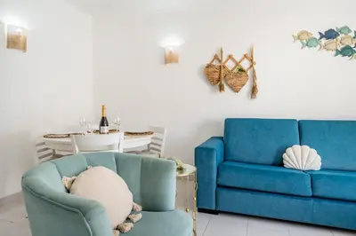 a living room with a blue couch and a chair at Stay in Old Town - 5 min walking to the beach in Albufeira