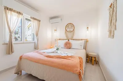 a bedroom with a bed with an orange blanket at Stay in Old Town - 5 min walking to the beach in Albufeira