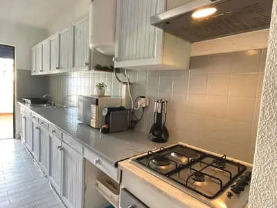 a kitchen with white cabinets and a stove top oven at Casa Caki - A 15 minutos da praia in Albufeira