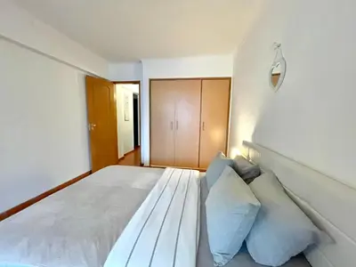 a bedroom with a large white bed with pillows at Casa Caki - A 15 minutos da praia in Albufeira