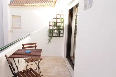 a patio with a table and two chairs and a staircase at Old Town Apartments 2D in Albufeira