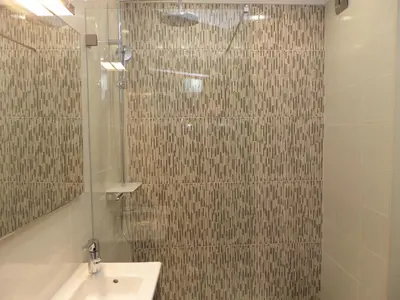 a bathroom with a shower with a sink and a mirror at Old Town Apartments 2D in Albufeira