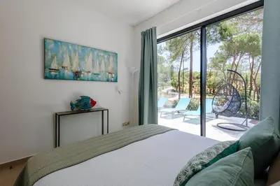 a bedroom with a bed and a large window at Casa da Calma, Vale do Lobo in Almancil
