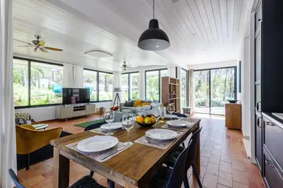 a kitchen and living room with a wooden table at Casa da Calma, Vale do Lobo in Almancil
