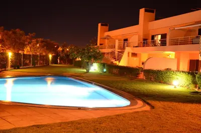 a swimming pool in front of a house at night at Vilamoura Paradisus Laguna with Patio and Pool in Quarteira