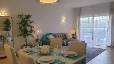 a living room with a table and a couch at Vilamoura Paradisus Laguna with Patio and Pool in Quarteira