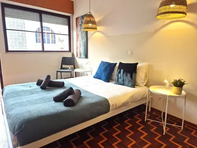 a bedroom with a large bed with blue pillows at Casa da Baixa in Faro