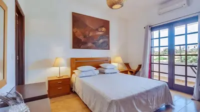 a bedroom with a bed and a large window at Villa Frederique in Albufeira