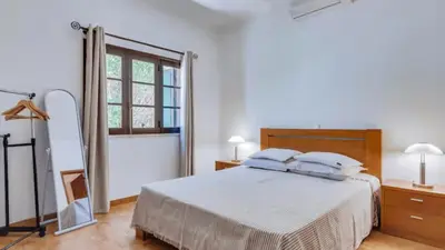 a white bedroom with a bed and a mirror at Villa Frederique in Albufeira