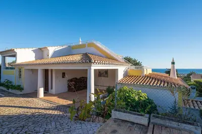 a white house with a fence in front of it at Villa Andrea in Albufeira