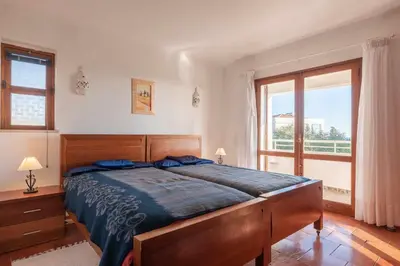 a bedroom with a bed and a large window at Villa Andrea in Albufeira