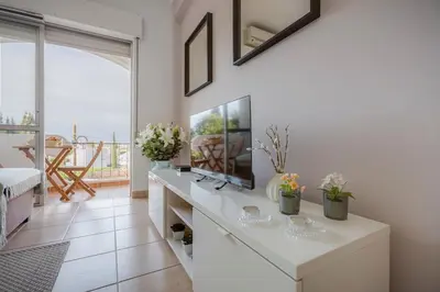 a living room with a white desk with flowers on it at ELI FLAT just few steps from the Strip in Albufeira in Albufeira