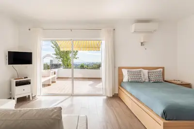 a bedroom with a bed and a view of a balcony at Estúdio 24 em Santa Bárbara de Nexe - Faro in Colmeal