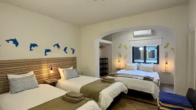 a bedroom with two beds and a room with dolphins on the wall at Vilanova by Check-in Portugal in Albufeira