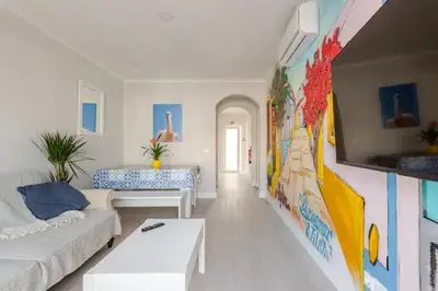 a living room with a white couch and a mural at BrisaMarVilas Sea view, 5 min Walk to Town & Beach 12e13 in Albufeira