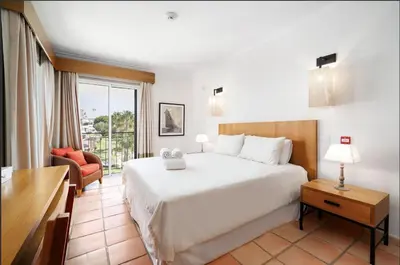 a bedroom with a large white bed and a balcony at 3 bedroom Vila Sol Golf Resort- 1st Floor in Quarteira