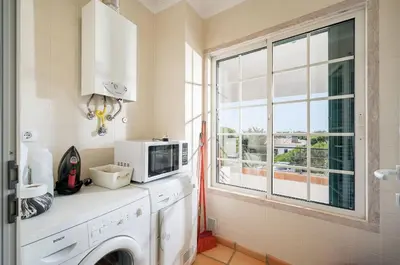 a kitchen with a microwave and a window at 3 bedroom Vila Sol Golf Resort- 1st Floor in Quarteira