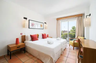 a bedroom with a large white bed and a desk at 3 bedroom Vila Sol Golf Resort- 1st Floor in Quarteira