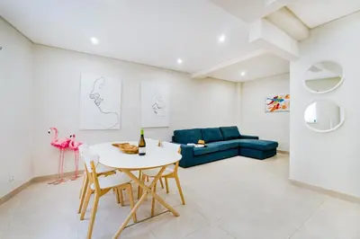 a living room with a table and a blue couch at Vivenda das Conchas - Just 50 Meters from the Beach in Quarteira