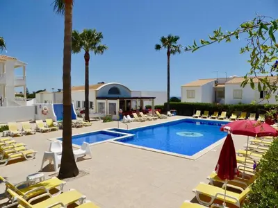 a swimming pool with lounge chairs and a resort at Casa Vela São Rafael in Albufeira