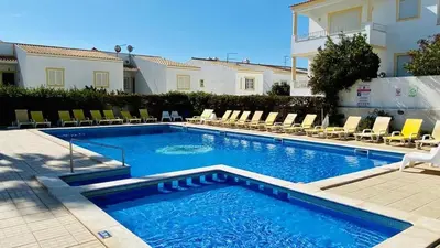 a swimming pool in front of a building at Casa Vela São Rafael in Albufeira