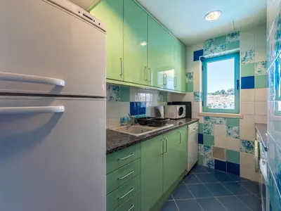 a kitchen with green cabinets and a white refrigerator at Luxury 1 Bedroom Apartment, Marina de Albufeira4 in Albufeira