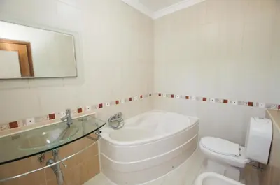 a white bathroom with a toilet and a sink at Villa Perla in Guia