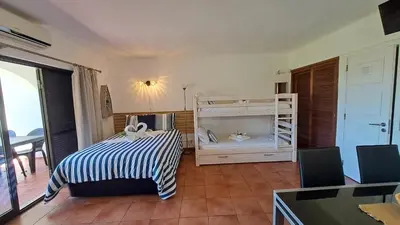 a bedroom with a bed and a table with chairs at SÃO RAFAEL BEACH Apartment 55 in Albufeira
