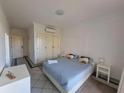 a bedroom with a blue bed and a table at Charming Villa Albufeira in Albufeira