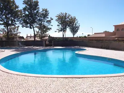 a large blue pool in a yard with trees at Charming Villa Albufeira in Albufeira