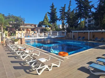 a pool with chaise lounge chairs and a swimming pool at Sun and Serenity in Albufeira