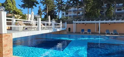 a swimming pool with blue chairs and a building at Sun and Serenity in Albufeira