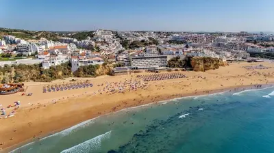 a bedroom with a large white bed with a window at Albufeira Sunny Days | Pool View Family Apartment in Albufeira