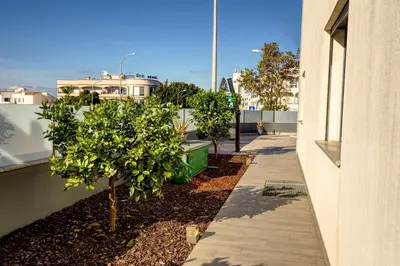 a sidewalk next to a building with trees on it at Modern Vacation Home With Pool In Quarteira in Quarteira