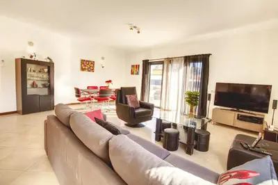 a living room with a large couch and a television at Modern Vacation Home With Pool In Quarteira in Quarteira