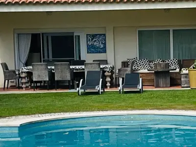 a swimming pool with chairs and a table and a patio at Vale do Lobo 5 Bed Villa with Large Pool overlooking Golf Course in Almancil