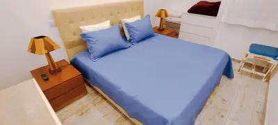 a bedroom with a large bed with blue pillows at Albufeira View Sea Apartment Luxury in Albufeira