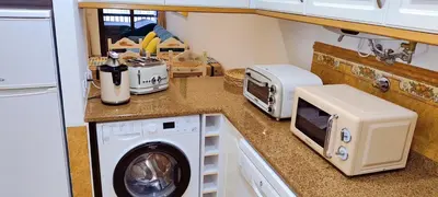 a kitchen with a washing machine and a microwave at Albufeira View Sea Apartment Luxury in Albufeira